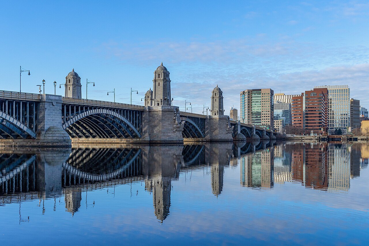 The Longfellow Bridge and its stone towers reflected in the still Charles River