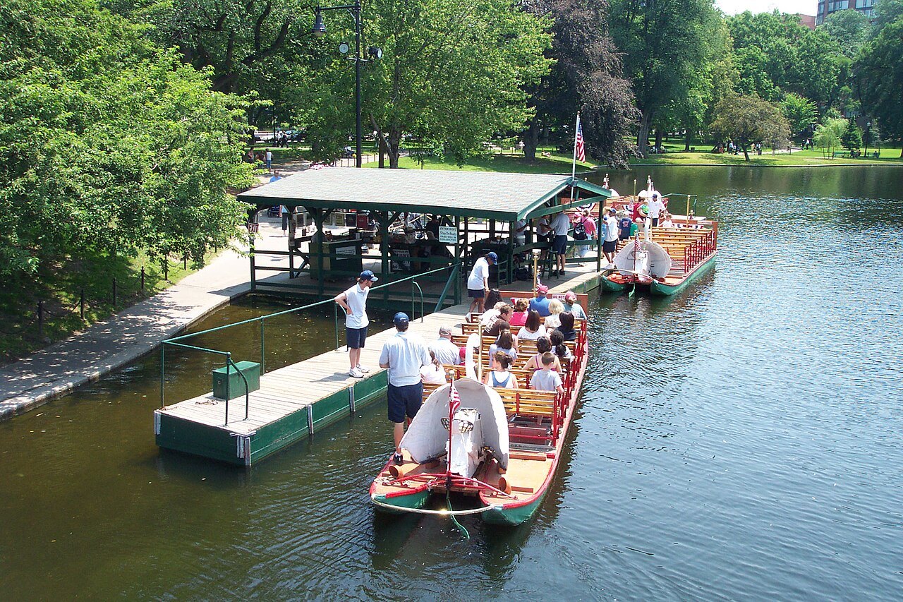 The Swan Boat dock on the Public Garden lagoon, a boat taking on passengers