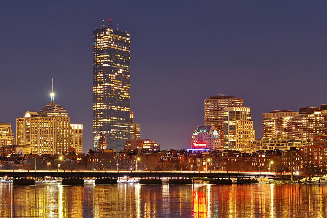 The Back Bay towers lit at night above the frozen Charles River