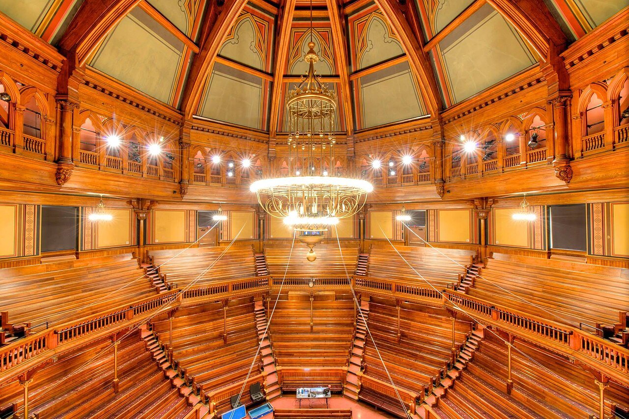 Sanders Theatre in Memorial Hall, its tiers of wooden seats under the carved roof