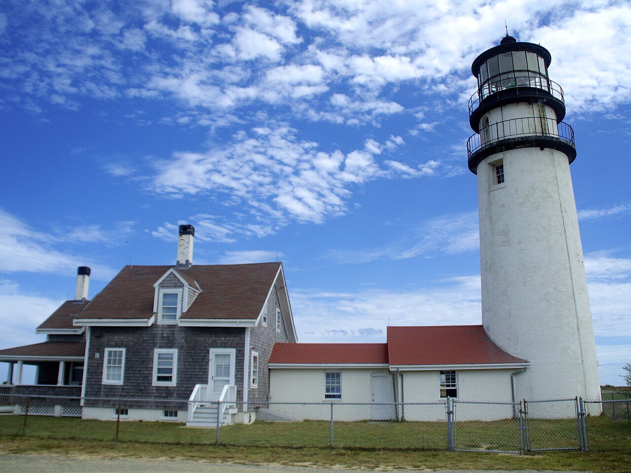 Highland Light in Truro, the white tower beside the keeper's house under a summer sky