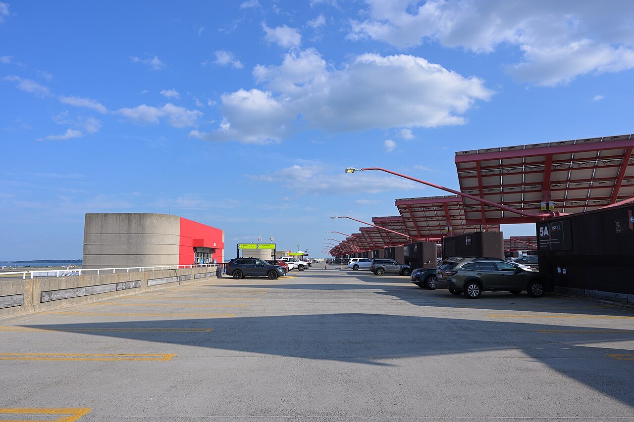 The rooftop of a Logan parking garage under summer clouds