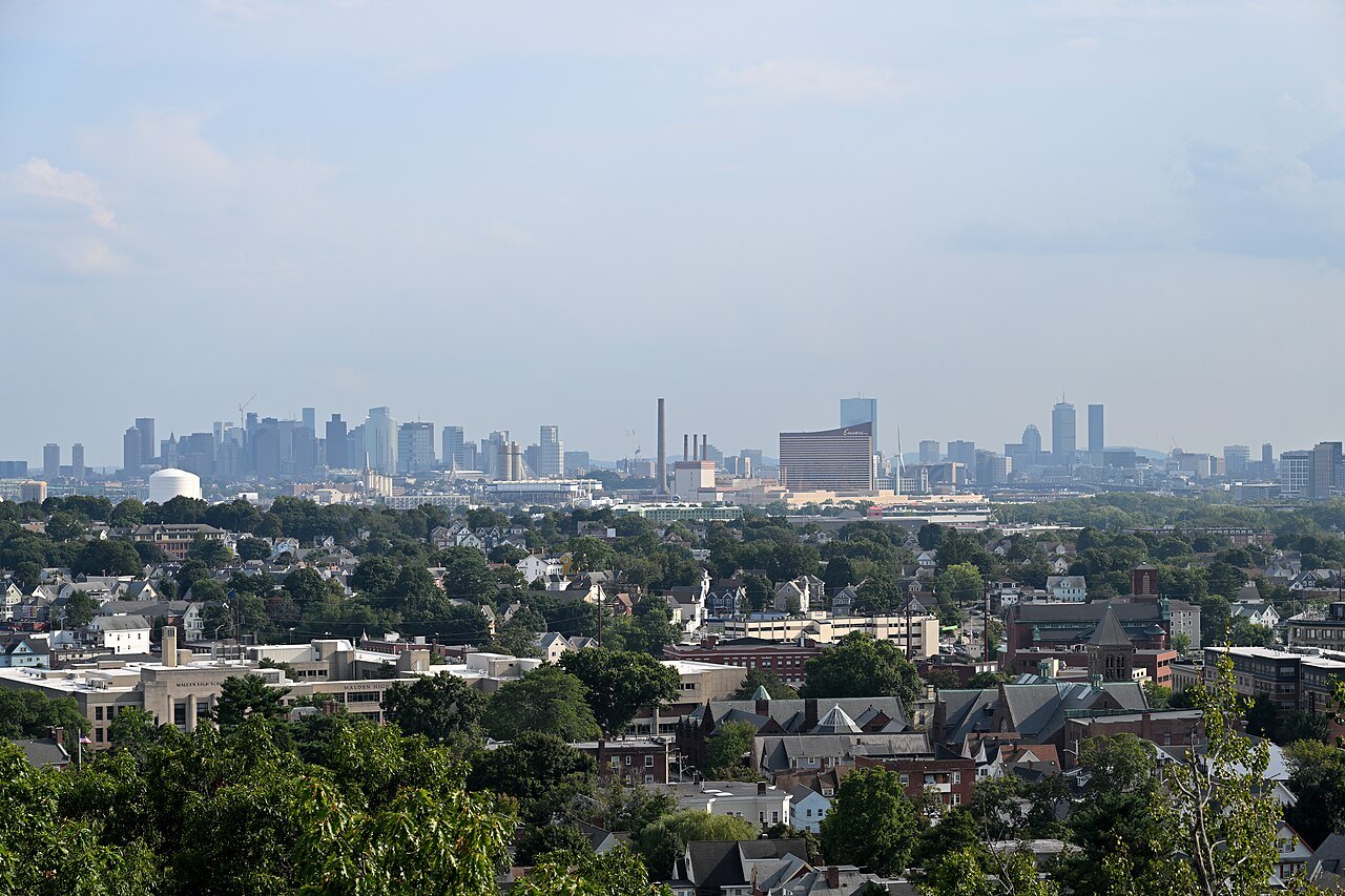 The Boston skyline far off across the rooftops of the suburbs from Waitt's Mountain in Malden