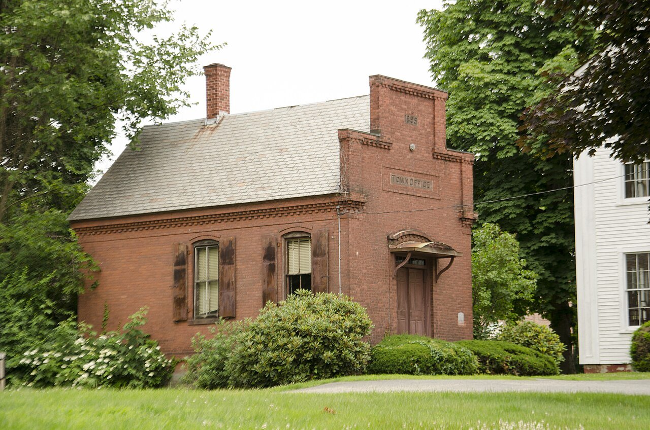 A small brick house of old Deerfield among green lawns