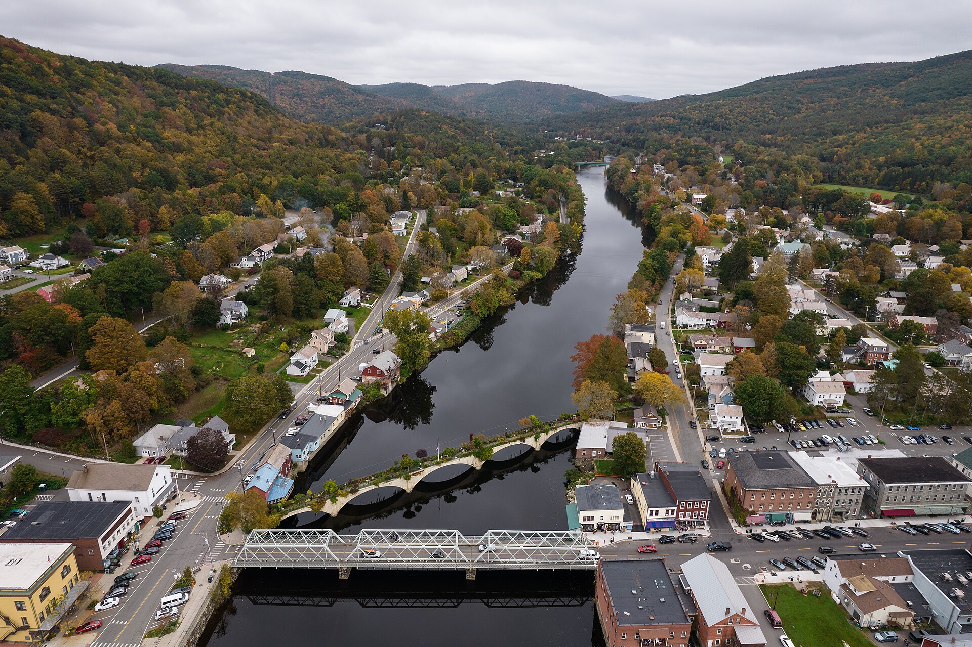 Shelburne Falls from the air in autumn, the Deerfield River winding between the hills