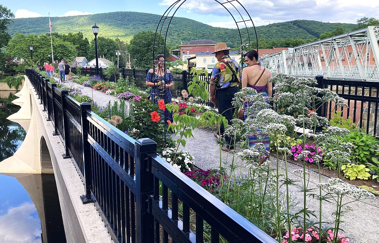 Visitors among the summer flowers on the Bridge of Flowers, the iron bridge beside it