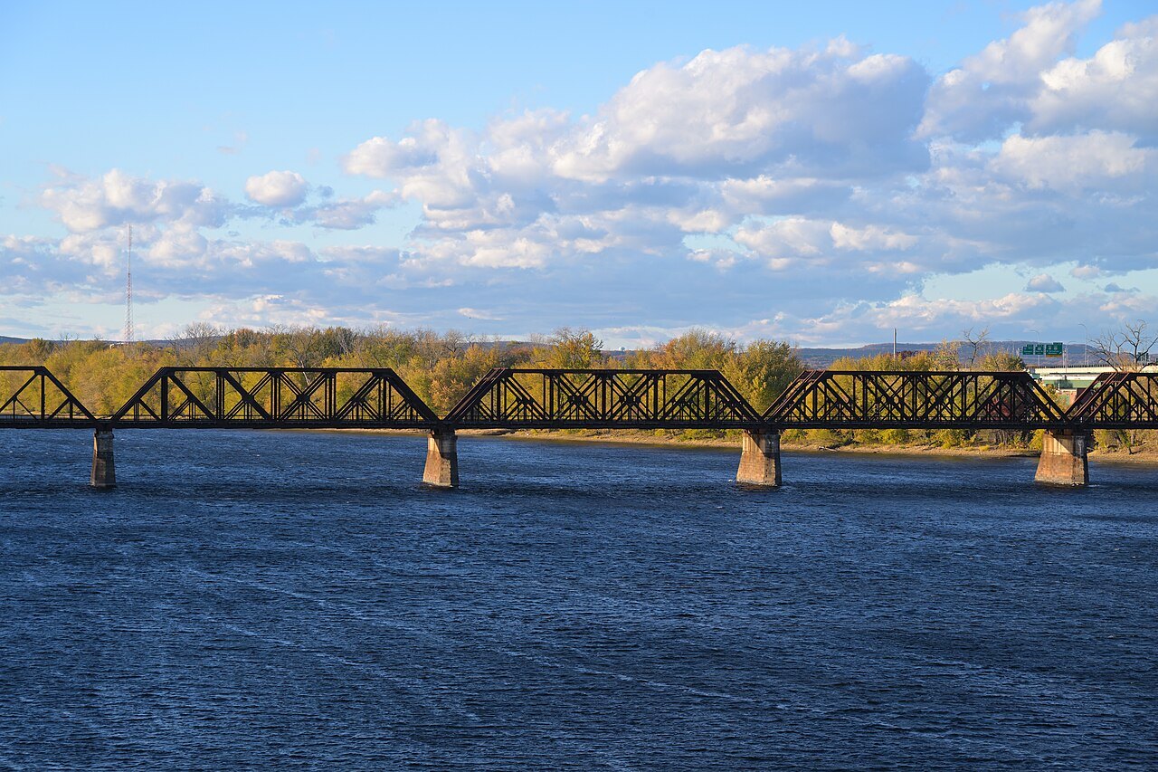 A railroad bridge across the Connecticut River under a blue autumn sky