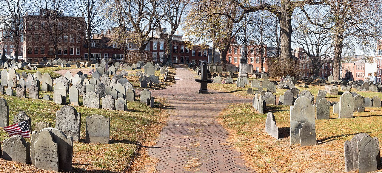 A brick path between the old slate headstones of Copp's Hill Burying Ground