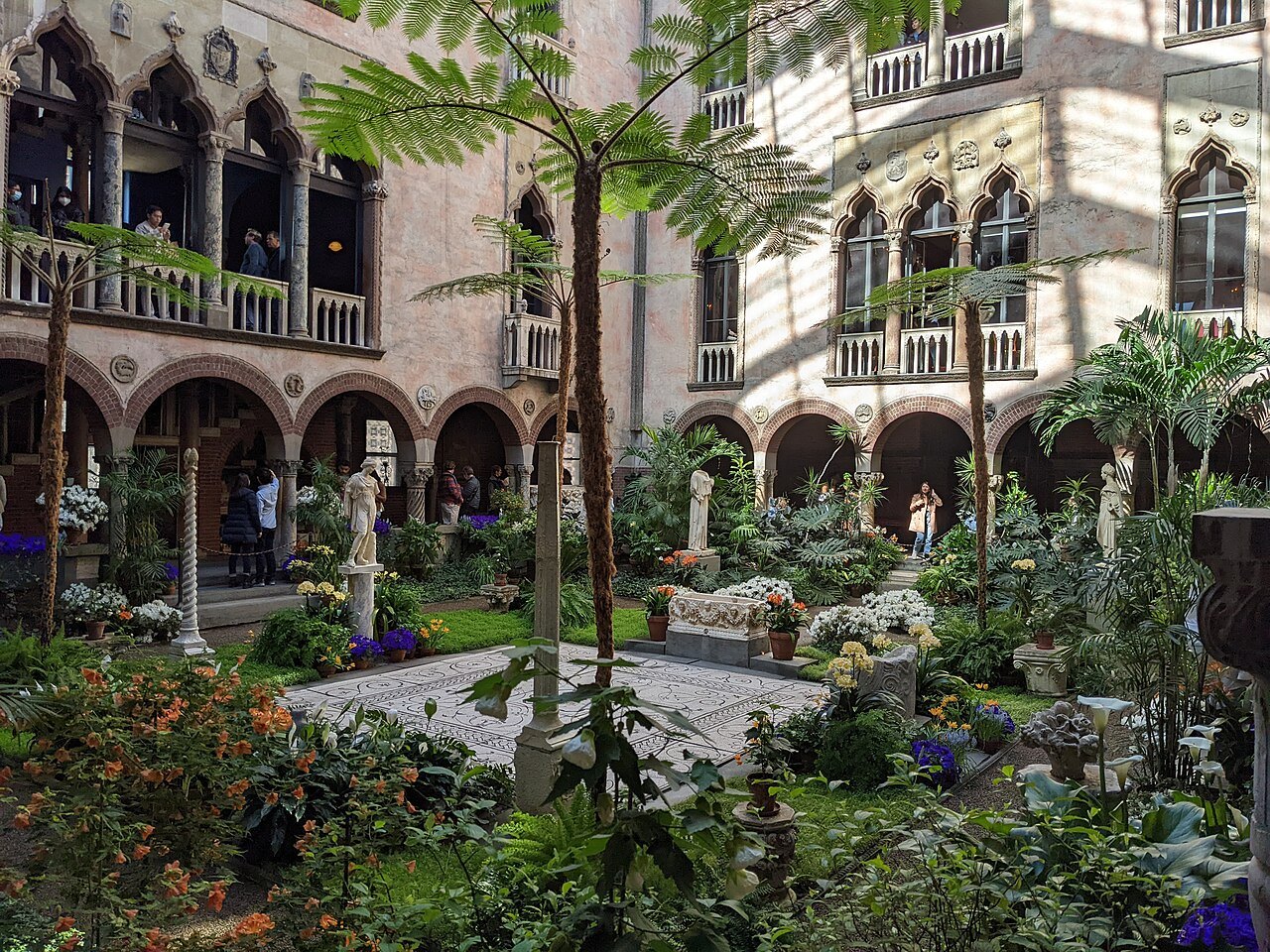 Palms, ferns and flowering plants filling the courtyard garden under the glass roof