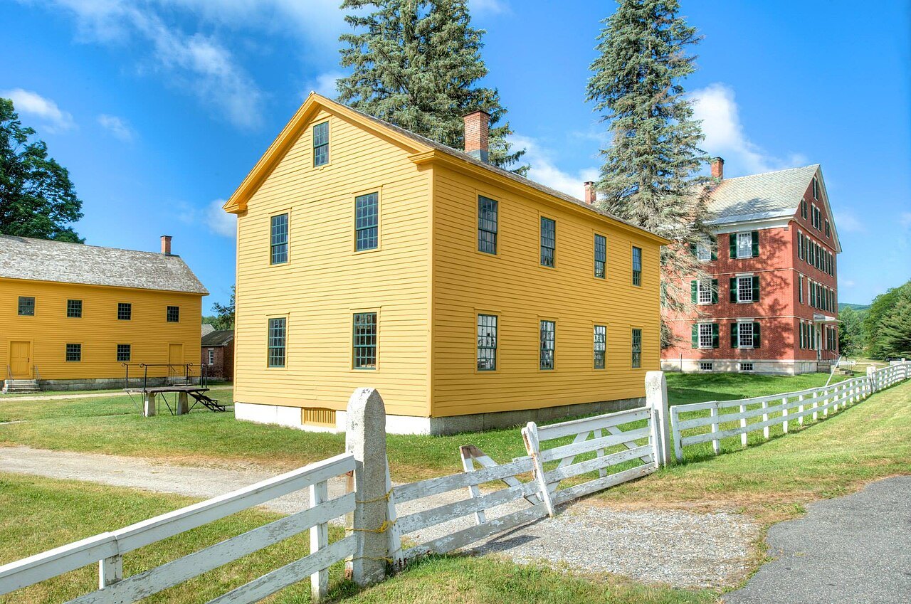 The yellow clapboard Brethren's Shop behind white fences