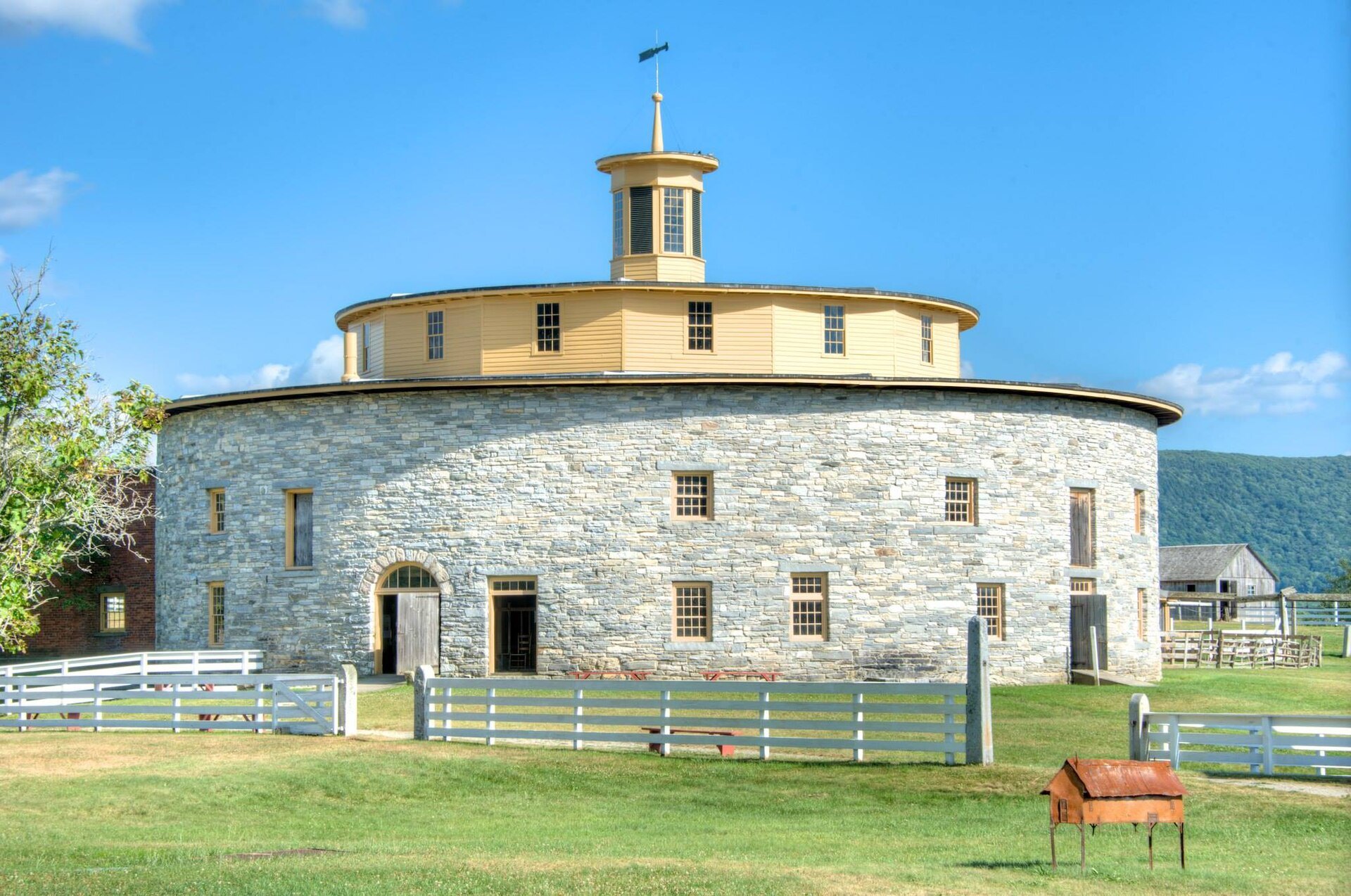 The Round Stone Barn of 1826 at Hancock Shaker Village, its yellow cupola above the stone drum