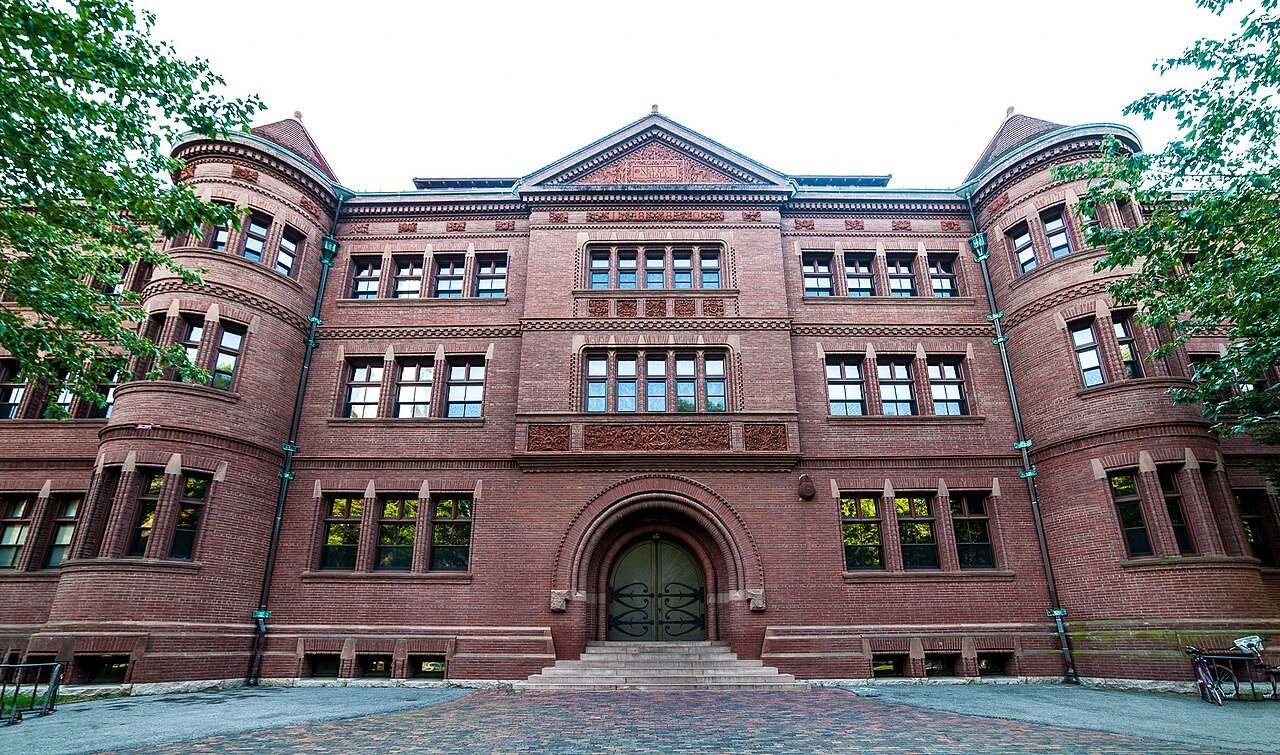 Sever Hall's brick front and arched entrance on a summer day