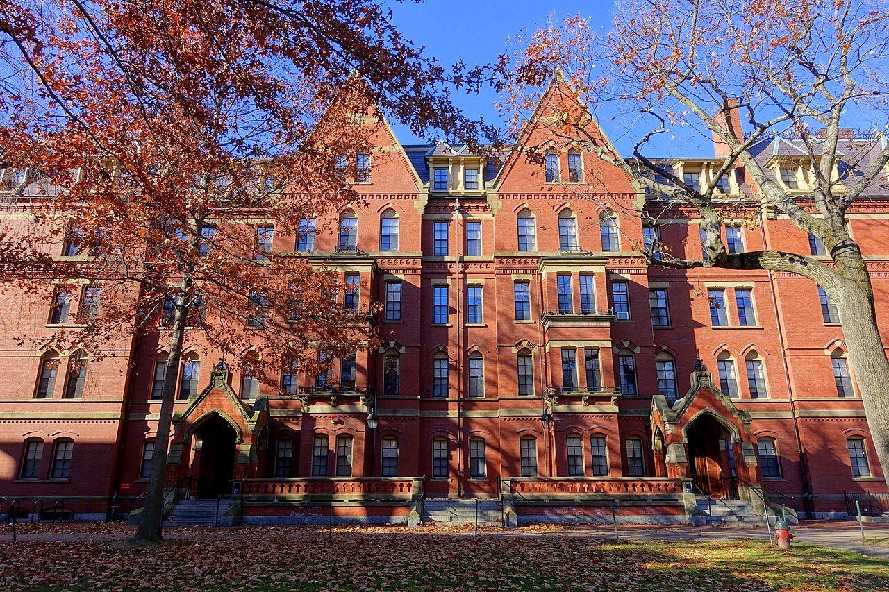 The red-brick gables of Matthews Hall under autumn leaves