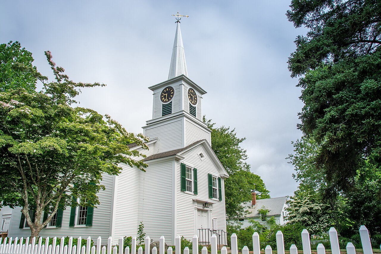 The white clapboard church in West Tisbury, its steeple among green trees