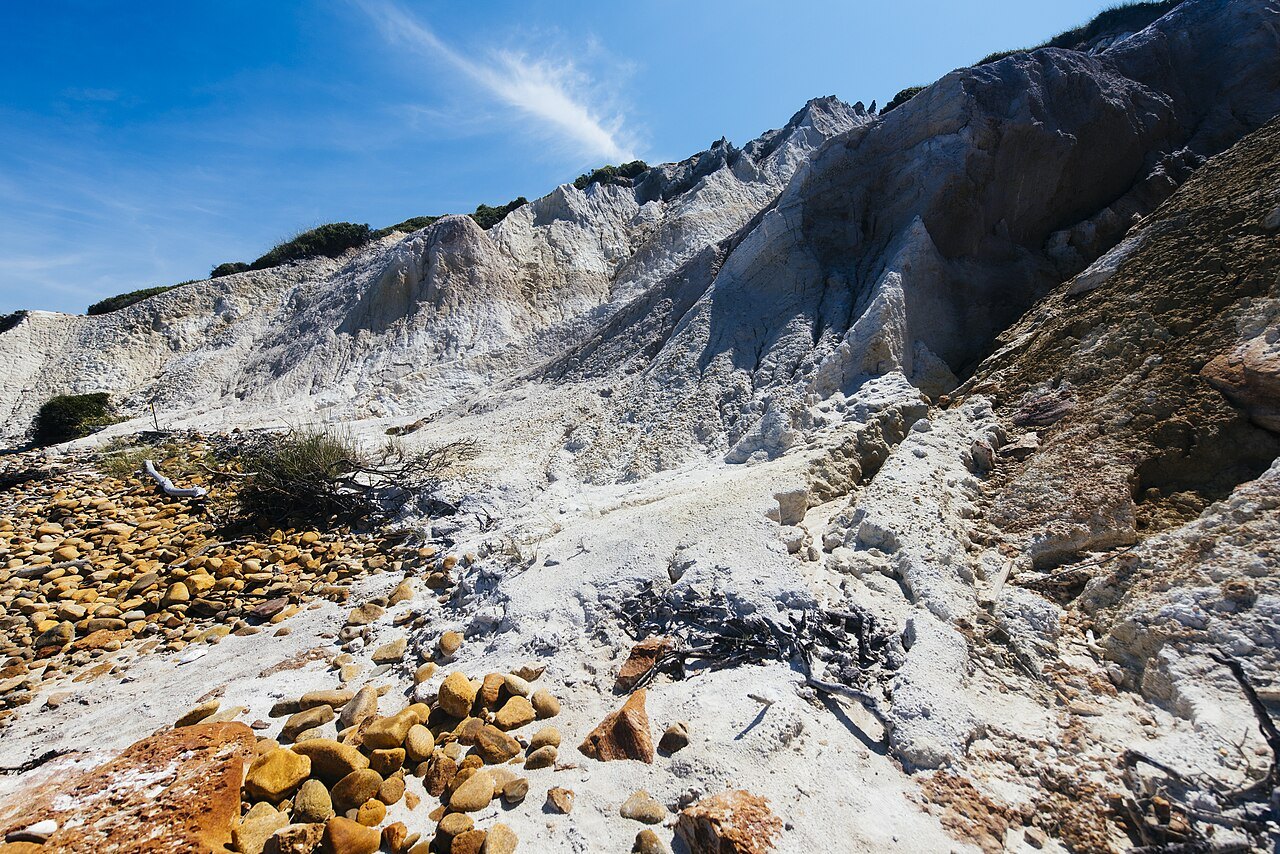 The pale clay of the Aquinnah cliffs close up, stones scattered at their foot
