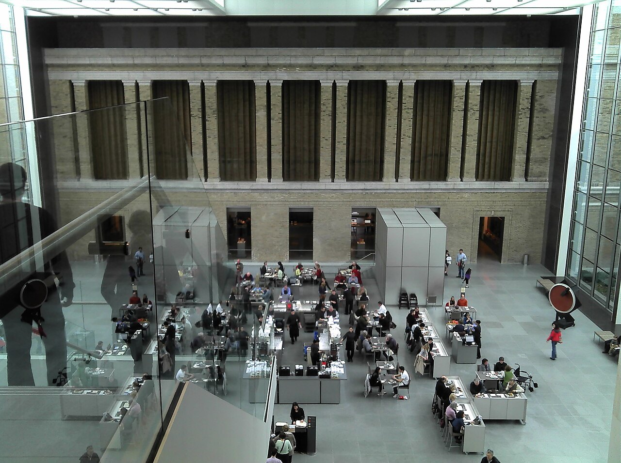 The glass-walled courtyard of the museum's newer wing, set with tables for visitors