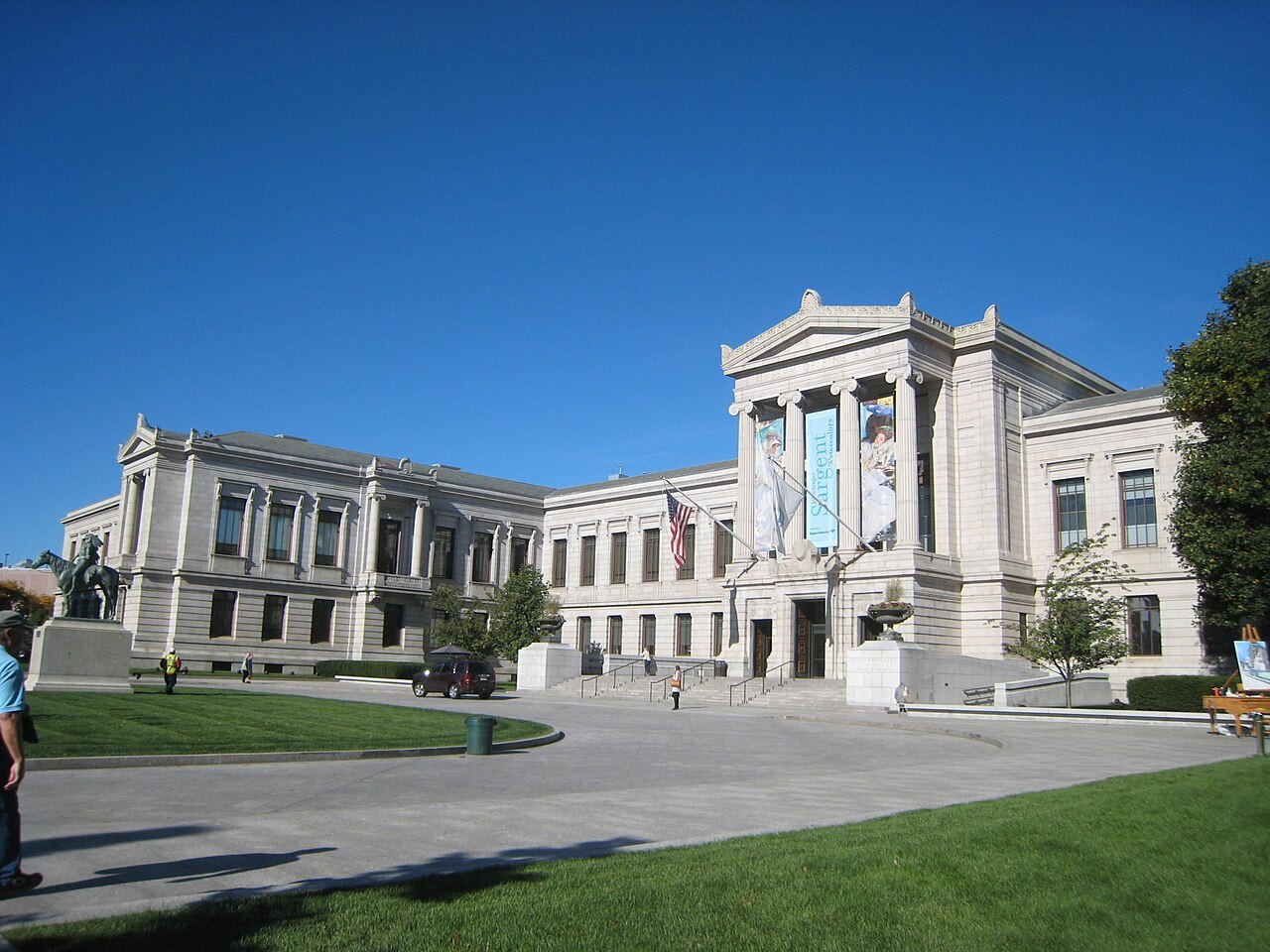 The long granite front of the museum under a deep blue sky