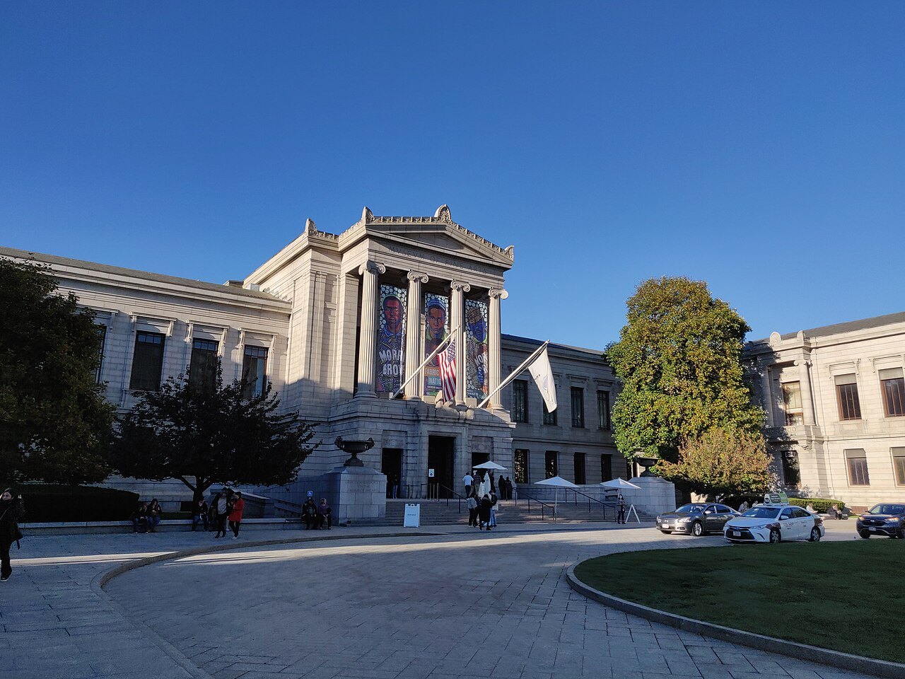 The museum seen from the curving drive, trees framing the entrance