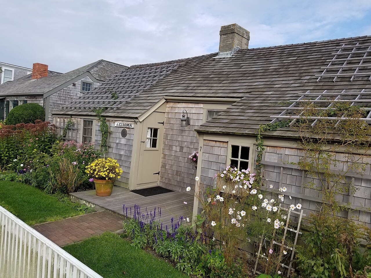 A shingled cottage in Siasconset, roses and summer flowers along its path