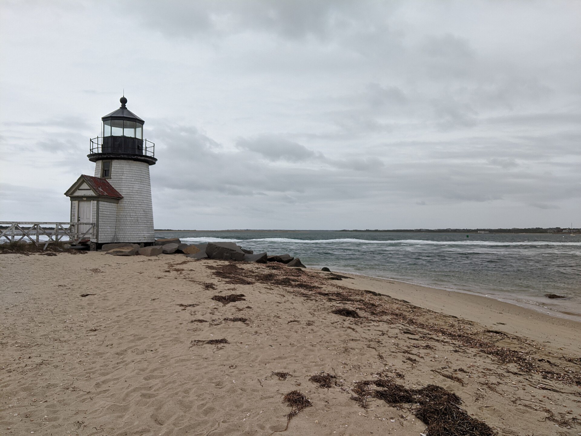 Brant Point Light, the small white lighthouse at the mouth of Nantucket harbor, above the beach