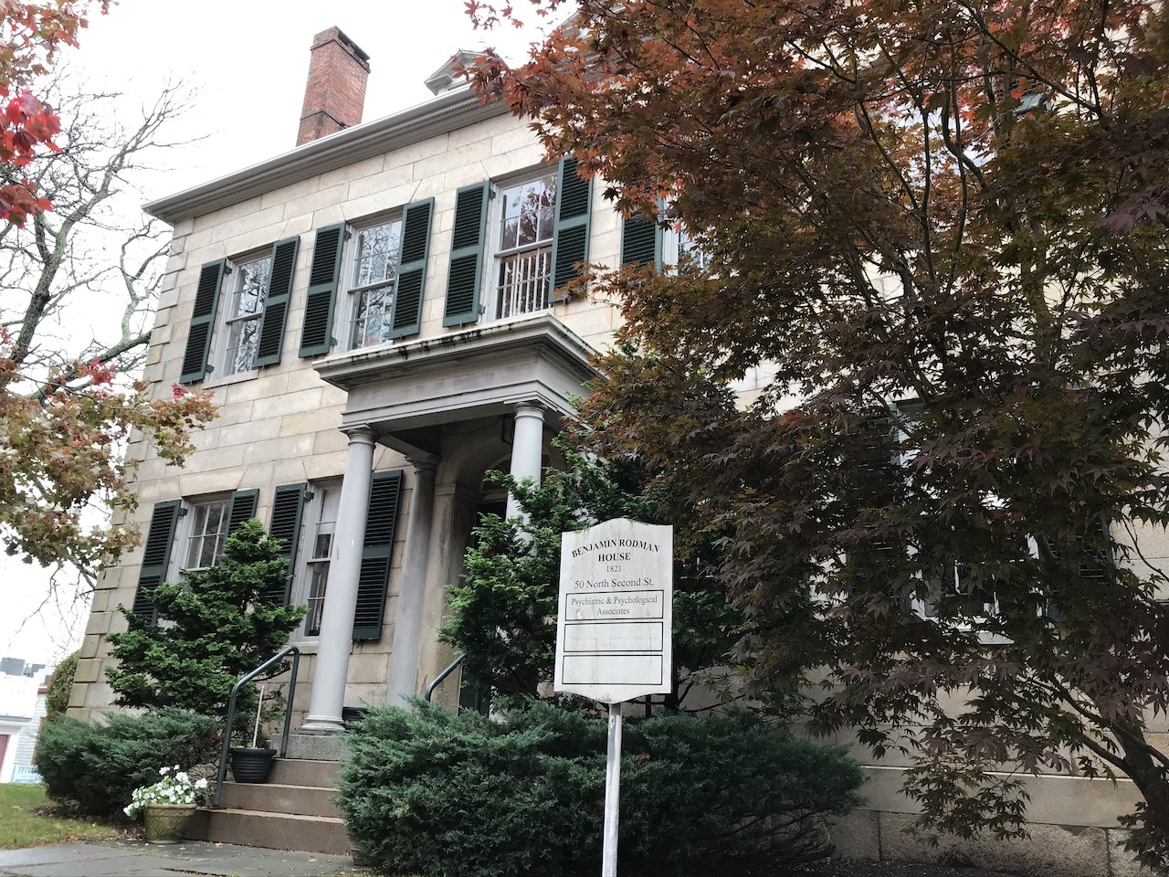 The Benjamin Rodman House, a stone mansion among autumn trees