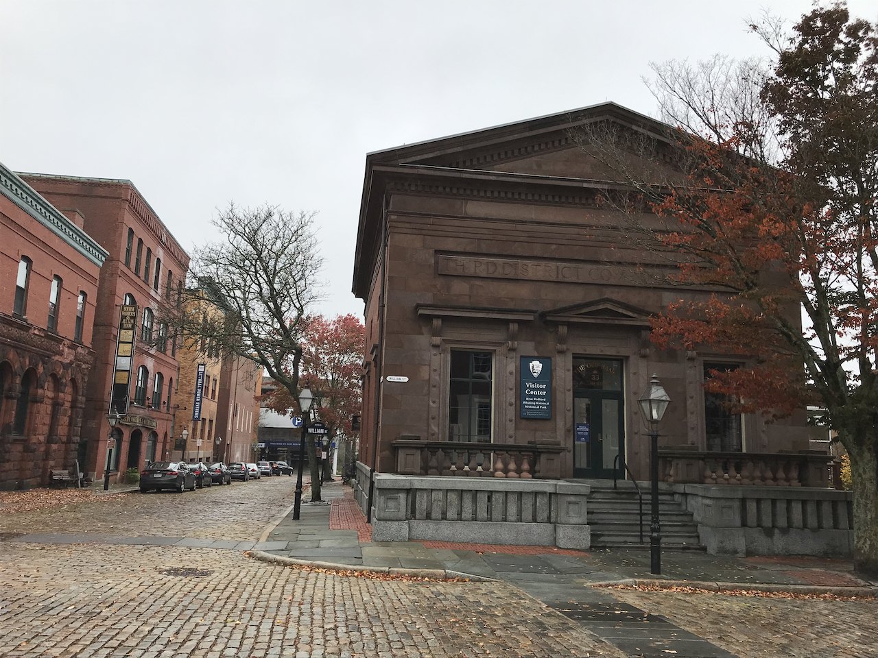 A stone building of the old business district on a cobbled street in autumn
