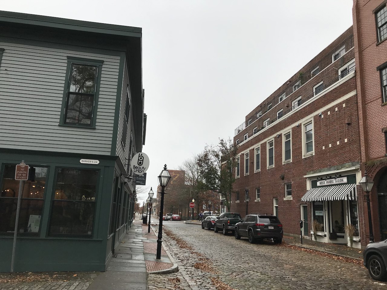 Cobbled Acushnet Avenue between old brick and clapboard buildings