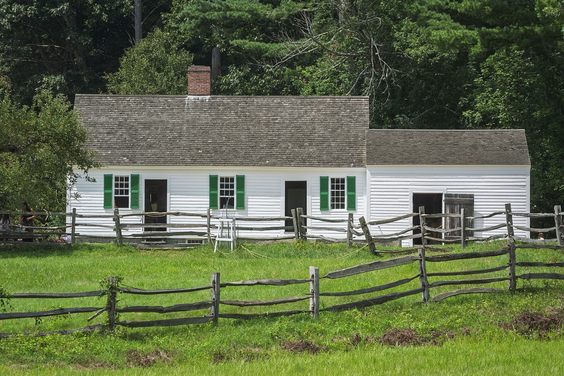 The Bixby House, a white clapboard farmhouse behind a split-rail fence at Old Sturbridge Village