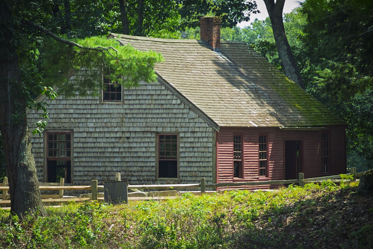 The Carding Mill, a shingled mill building with a red end, among the trees