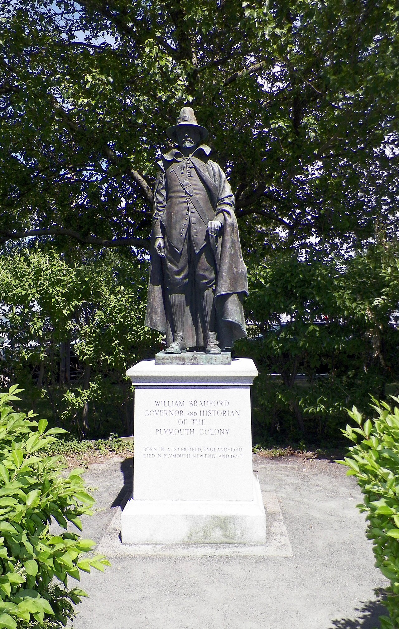 The statue of William Bradford, governor of the colony, among green trees