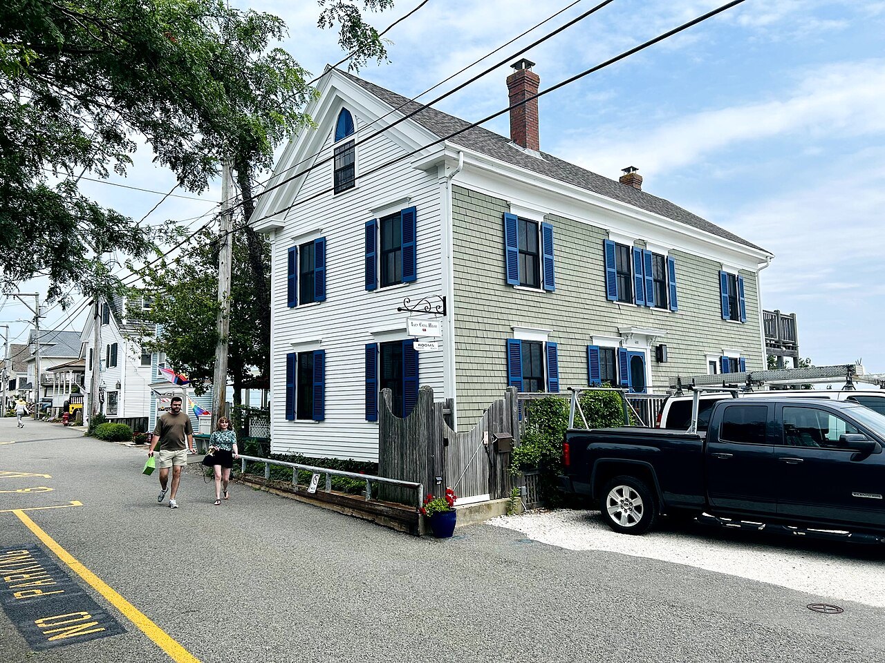 The Lucy Cross House, a clapboard house with blue shutters on a Provincetown street