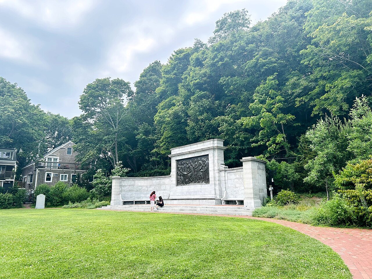 The Bas-Relief memorial, a white stone monument in a small park below the woods