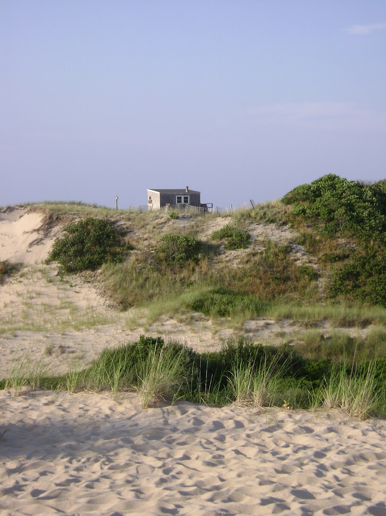 A weathered dune shack on the crest of the sand