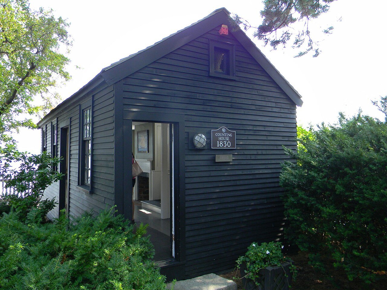 A small dark counting house among the shrubs
